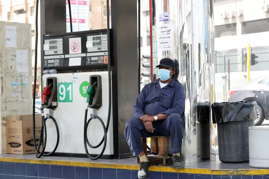 A gas station worker wearing a protective face mask sits next to a petrol station, after Saudi Arabia imposed a temporary lockdown on the province of Qatif following the spread of coronavirus, in Qatif, Saudi Arabia March 9, 2020.
