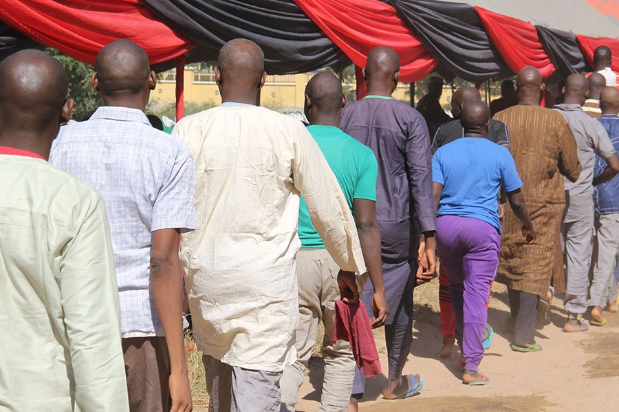 Freed inmates walk in a line after they were released to state officials for rehabilitation and integration after they were detained for up to four years over suspicion of links with Boko Haram at an official ceremony in Maiduguri, on November 27, 2019.