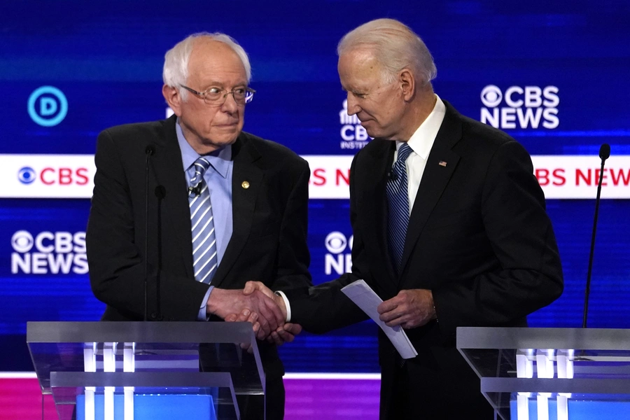 Presidential candidates Senator Bernie Sanders (L) and former Vice President Joe Biden (R) shake hands at the February 25 Democratic debate in Charleston, South Carolina. 