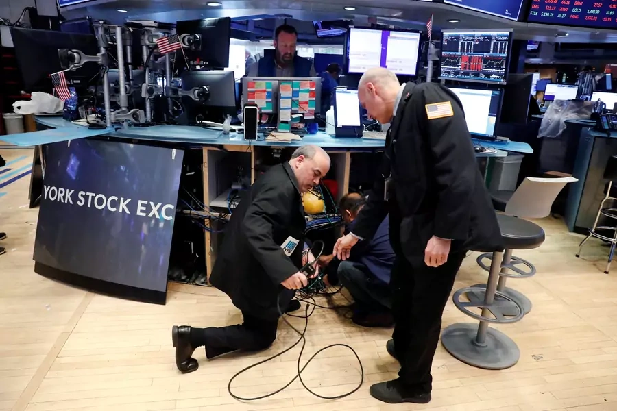 Traders remove computer equipment to work from home on the floor of the New York Stock Exchange (NYSE).