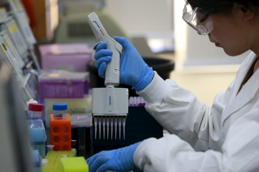 A researcher uses a pipette to develop assay to detect specific gene of corn at a lab in Syngenta Biotech Center in Beijing.