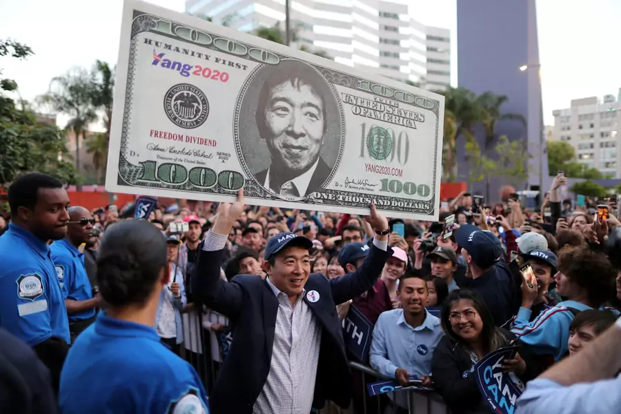 U.S. Democratic presidential candidate Andrew Yang hoists a supporter's sign after speaking at a rally in downtown Los Angeles, California, U.S., April 22, 2019.