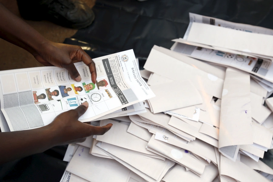 Electoral officials count votes at a polling station in Uganda's capital Kampala February 18, 2016