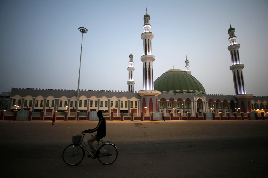 A man cycles past the Al Ansar mosque in Maiduguri, Nigeria, on February 16, 2019. Both Yusuf and Adam preached there in the early 2000s.
