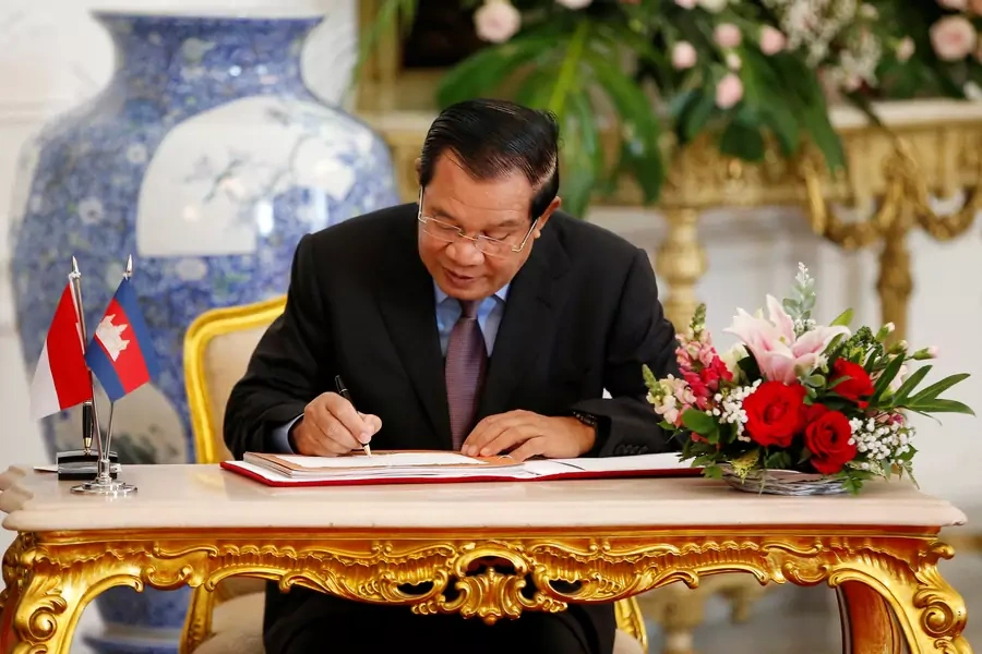 Cambodian Prime Minister Hun Sen signs a guest book during his meeting with Indonesian President Joko Widodo.