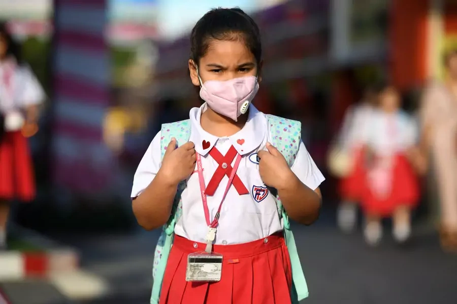 A girl arrives to school wearing a protective mask in Ayutthaya, outside Bangkok, Thailand February, 2020.