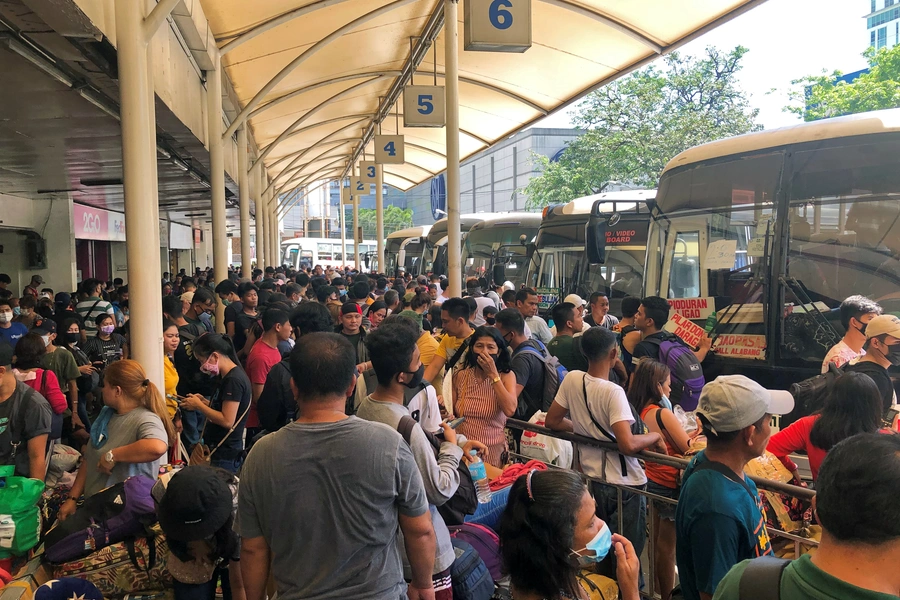 Passengers wear protective masks while waiting at the Araneta Center Bus Terminal in Cubao, Quezon City, Philippines, on March 13, 2020, following President Rodrigo Duterte's announcement of a local travel ban in the Philippine capital