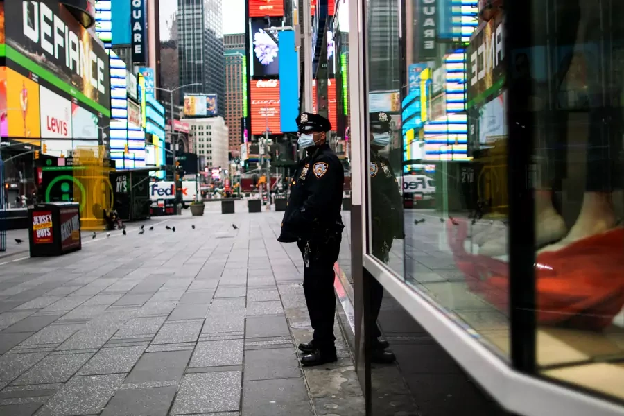 A New York Police officer stands guard in an almost empty Times Square during the outbreak of the coronavirus disease (COVID-19) in New York City, U.S., March 31, 2020.