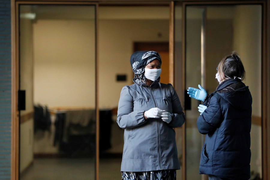 Women speak while they wait to be checked by a medical team as the spread of coronavirus disease (COVID-19) continues, in Rome, Italy, April 3, 2020. 