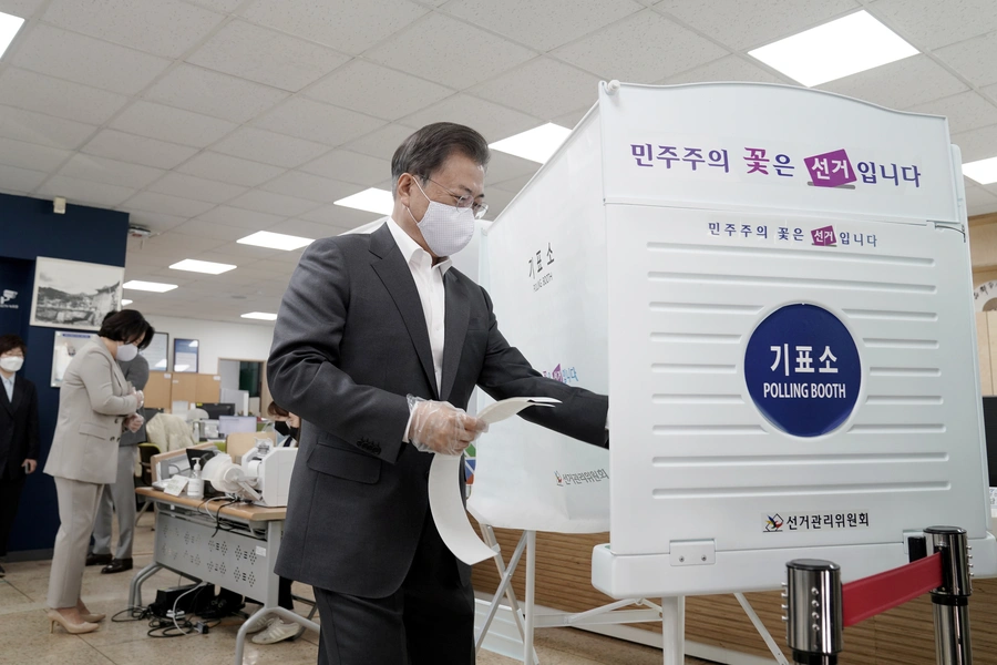 South Korean President Moon Jae-in wears a mask and plastic gloves to protect against COVID-19 as he votes in the parliamentary elections at a polling station in Seoul, South Korea, on April 10, 2020.