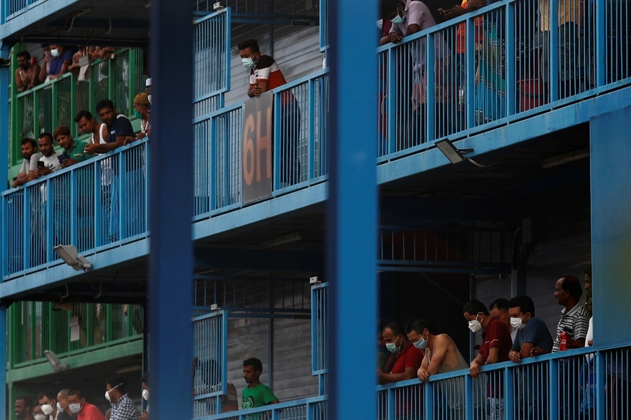 Migrant workers look out from their balconies at Punggol S-11 dormitory, during the coronavirus outbreak in Singapore on April 6, 2020.