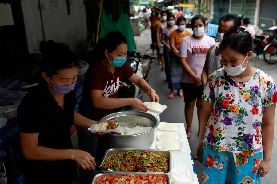 Volunteers give food to migrant workers from Myanmar who lost their jobs following the COVID-19 outbreak in Bangkok, Thailand April 23, 2020.