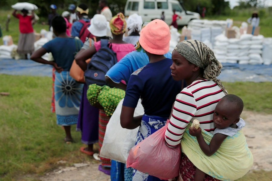 Villagers queue to collect food aid distributed by the World Food Program (WFP) following a prolonged drought in rural Mudzi district, Zimbabwe, February 20, 2020