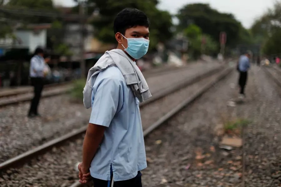 A boy wearing a protective mask waits for a train in Bangkok, Thailand, on April 27, 2020.