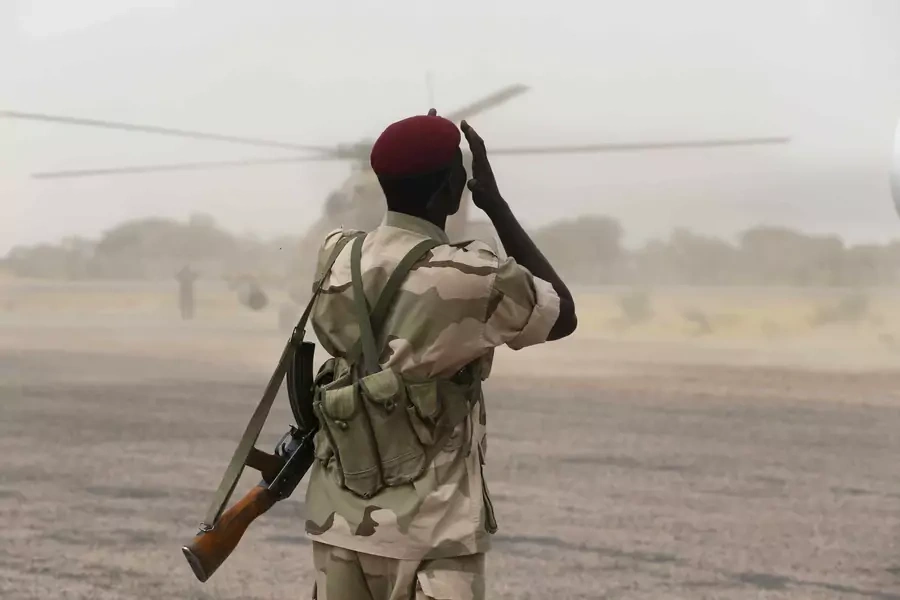 A Chadian soldier shields his face from dust kicked up by a helicopter in the recently retaken town of Damasak, Nigeria, on March 18, 2015.