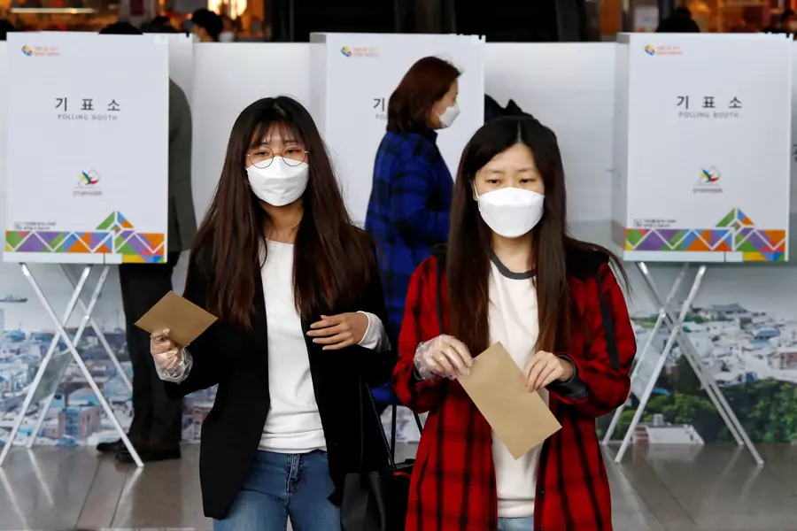 Women wearing masks to prevent contracting COVID-19 cast their ballots for the parliamentary election at a polling station in Seoul, South Korea.