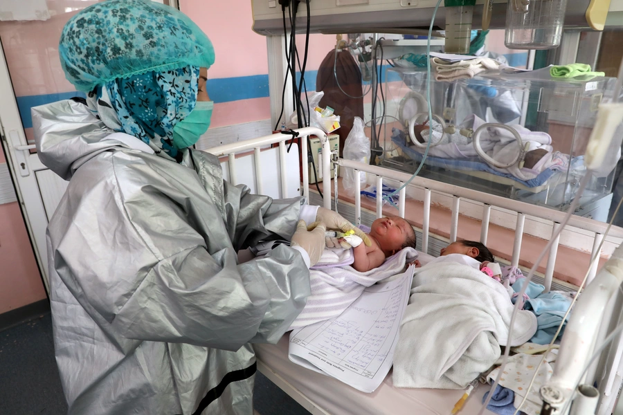 An Afghan nurse observes newborn children who lost their mothers during an attack at a hospital, in Kabul, Afghanistan May 13, 2020.