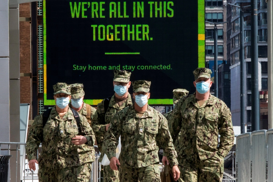 U.S. military personnel wearing face masks arrive at the Jacob K. Javits Convention Center in New York on April 7, 2020.