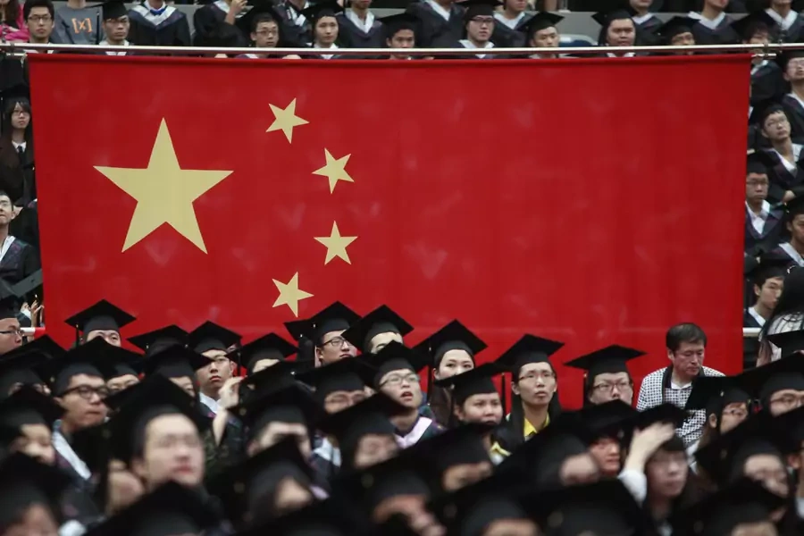 Graduates set next to the Chinese flag during a graduation ceremony.