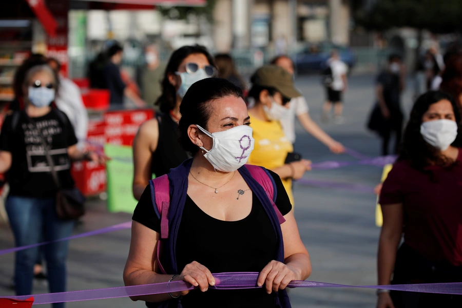 Women keep social distance by holding onto purple ribbons as they protest against domestic violence, amid the spread of COVID-19, in Istanbul, Turkey, May 20, 2020.