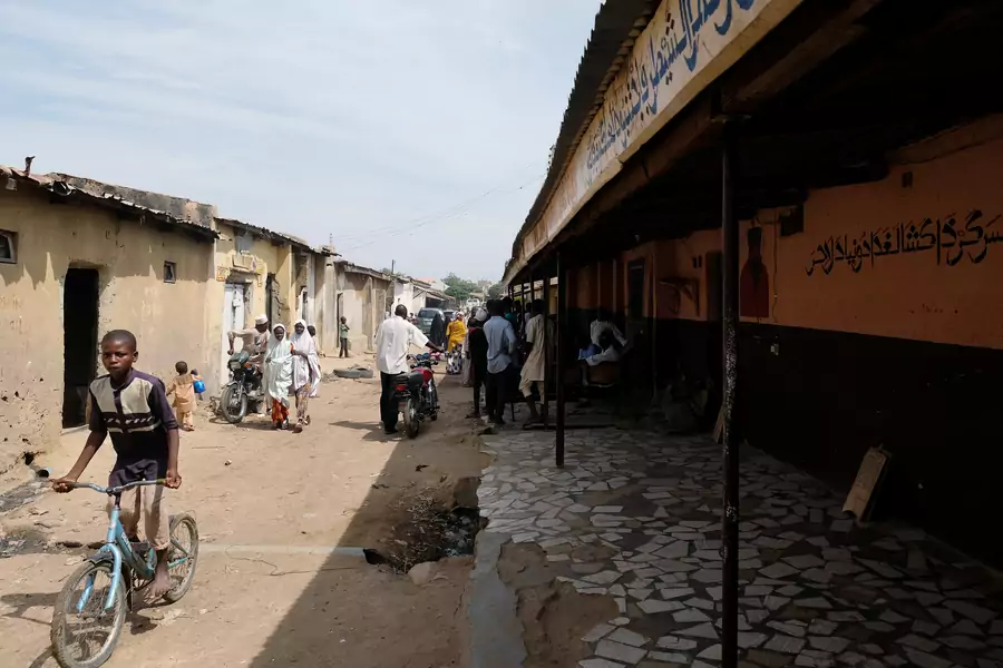 People pass by the site of Mallam Nigas’s Islamic school and rehabilitation center, which was raided by police last week, in Katsina, Nigeria, on October 18, 2019.