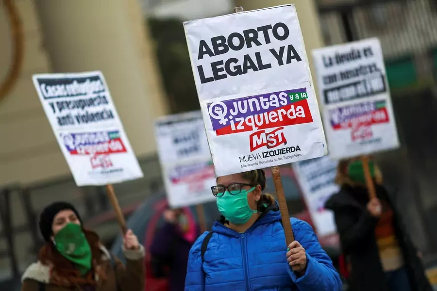 A demonstrator wearing a face mask holds a placard that reads "Legal Abortion Now", on the 5th anniversary of the "Ni Una Menos" movement, in Buenos Aires, Argentina June 3, 2020.