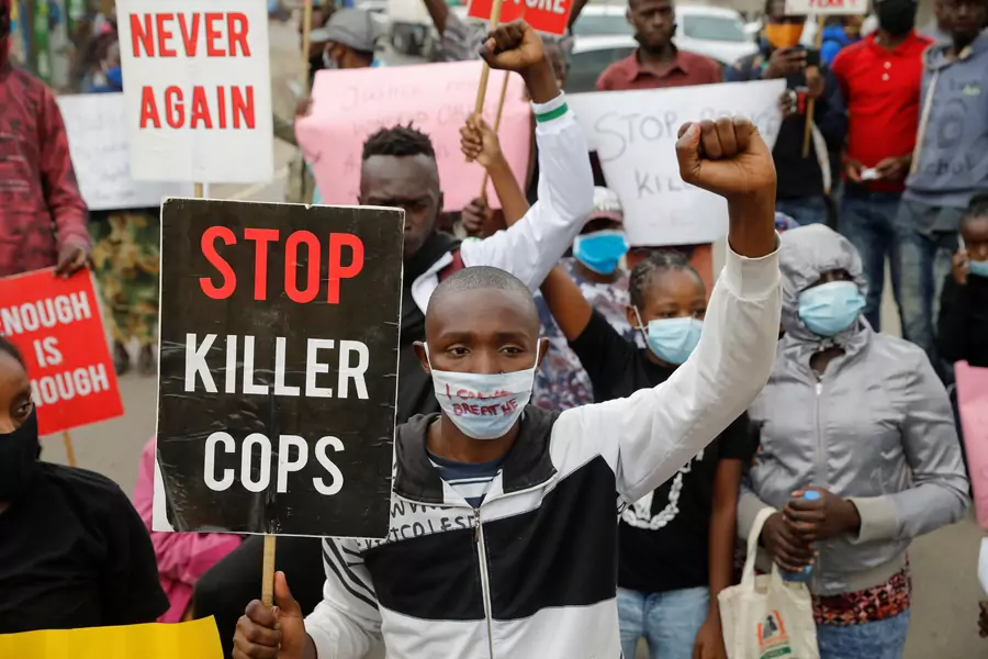 Protesters hold signs and placards during a demonstration against police killings and brutality, in the Mathare slum in Nairobi, Kenya, June 8, 2020. 