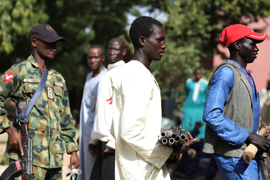 Members of the Yansakai vigilante group bring their weapons into a government building as members surrendered more than five hundred guns to Zamfara Governor Bello Matawalle as part of a peace process, in Gusau, Zamfara, Nigeria, on December 3, 2019.