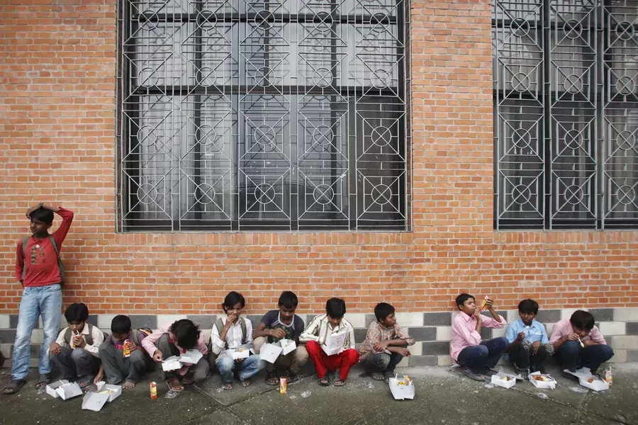 Child laborers eat their lunch after being rescued from squalid working conditions a sari embroidery factory, with the help of Nepalese police and child rights organizations, near Kathmandu, 2012.