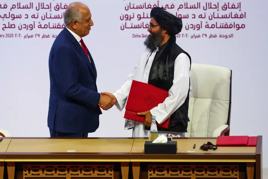 Mullah Abdul Ghani Baradar, the leader of the Taliban delegation, and Zalmay Khalilzad, U.S. envoy for peace in Afghanistan, shake hands after signing an agreement at a ceremony between members of Afghanistan's Taliban and the United States in Doha, Qatar