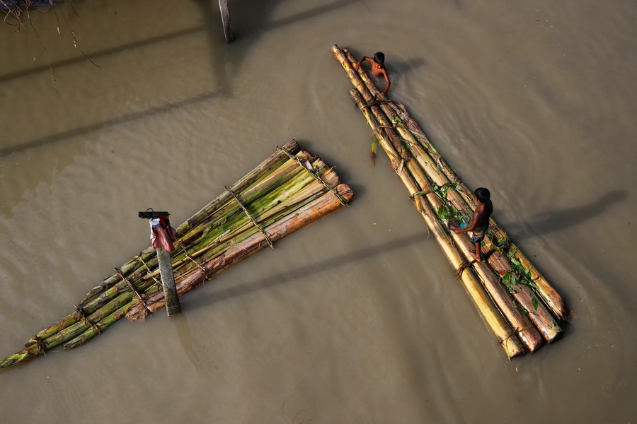 Children on makeshift rafts in a flooded area of Jamalpur, Bangladesh.