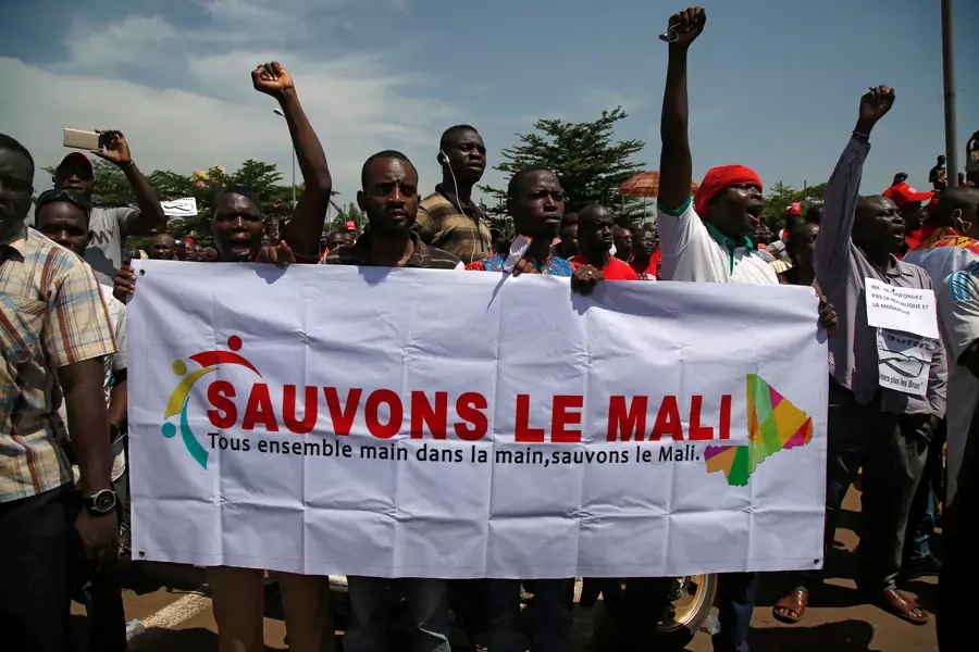 Supporters of the Malian opposition hold a banner as they gather for a meeting to protest against plans to revise the constitution, in Bamako, Mali on July 1, 2017. The banner reads "Let's save Mali, all together hand in hand, let's save Mali."