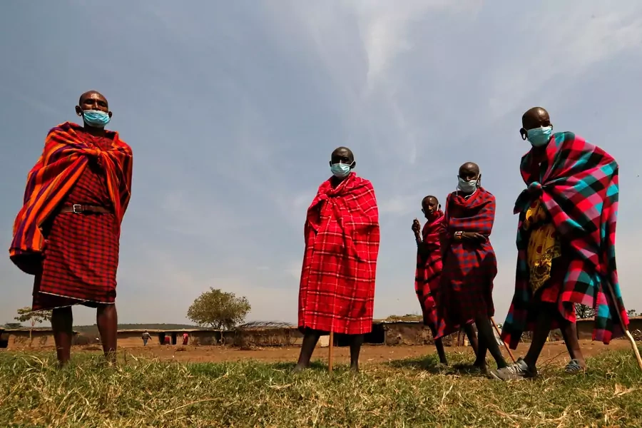 Maasai elders, wearing traditional costumes with face masks on, gather at their homestead within the Orboma Manyatta in Sekenani, near the Maasai Mara game reserve in Narok County, Kenya, on August 10, 2020.