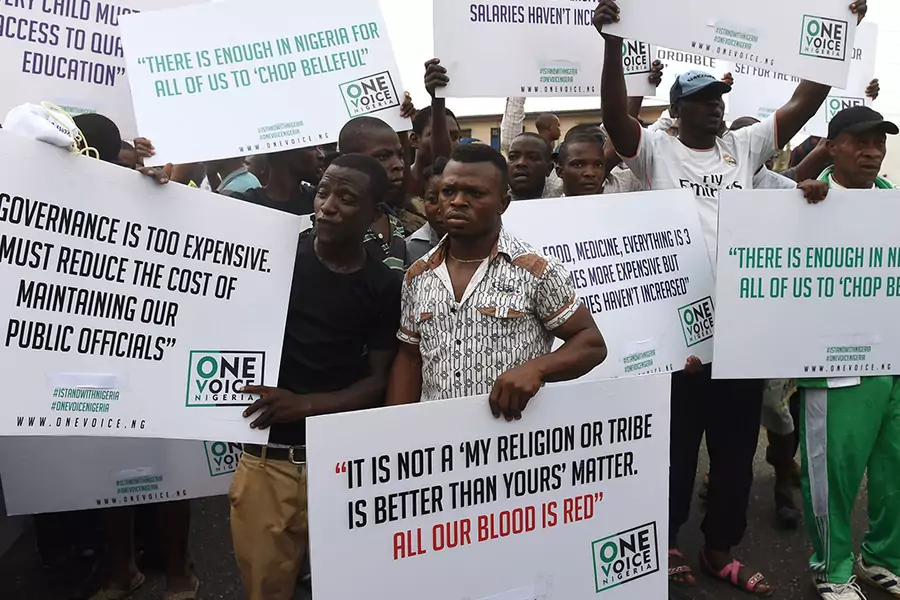 Protesters hold placards during an anti-government demonstration in Lagos, on February 6, 2017, to protest against the prevailing economic hardship, high cost of living, and the government's handling of the economic crisis in the country.