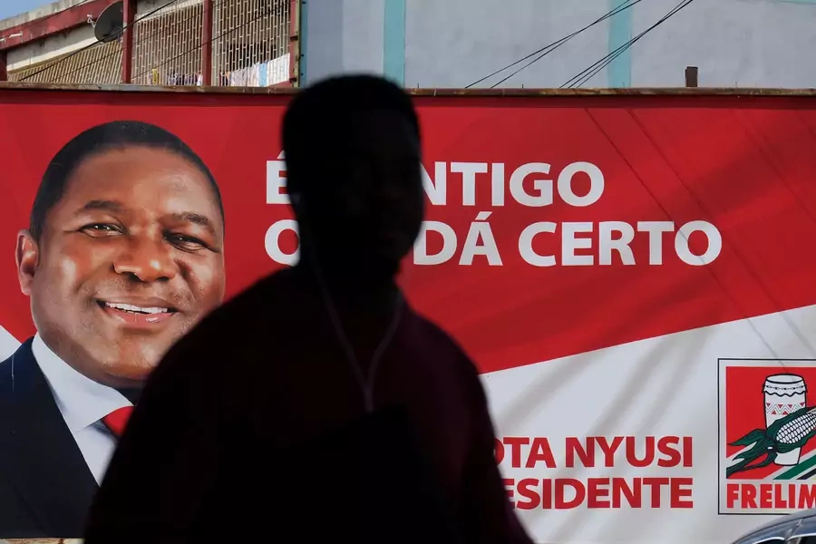 A local walks past a billboard with a picture of Mozambique's president and leader of the Frelimo Party, Filipe Nyusi, in Maputo, Mozambique, October 11, 2019