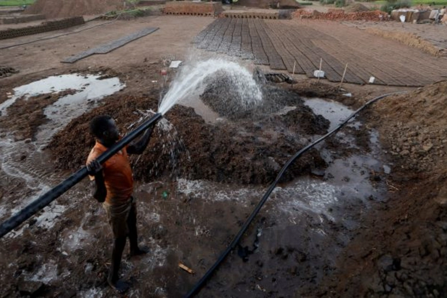 Zaki El-Dine pours water from the Nile river onto a patch of mud to make bricks on Khartoum, Sudan on February 12, 2020. 