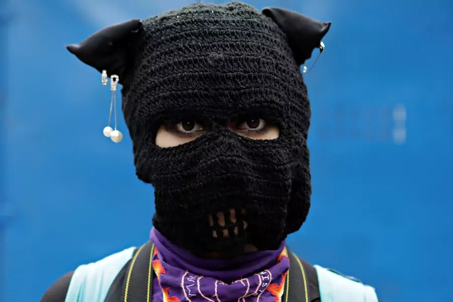 A masked woman participates in a march to demand justice for victims of gender-based violence and femicides in Mexico City, Mexico. August 16, 2020.