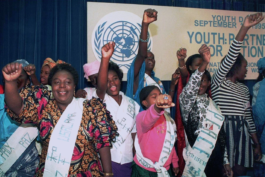 Gertrude Mongella (L), then-secretary-general of the UN fourth world conference on women, sings along with an African women’s youth group. Beijing, China. September 11, 1995.