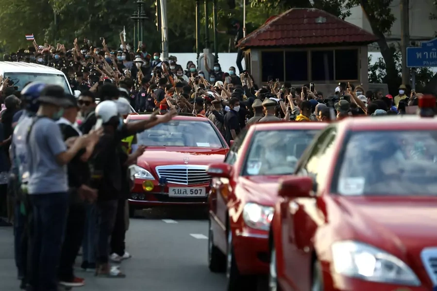 Pro-democracy demonstrators flash a three-finger salute as a royal motorcade drives past during a Thai antigovernment mass protest, on the 47th anniversary of the 1973 student uprising, in Bangkok, Thailand on October 14, 2020. 