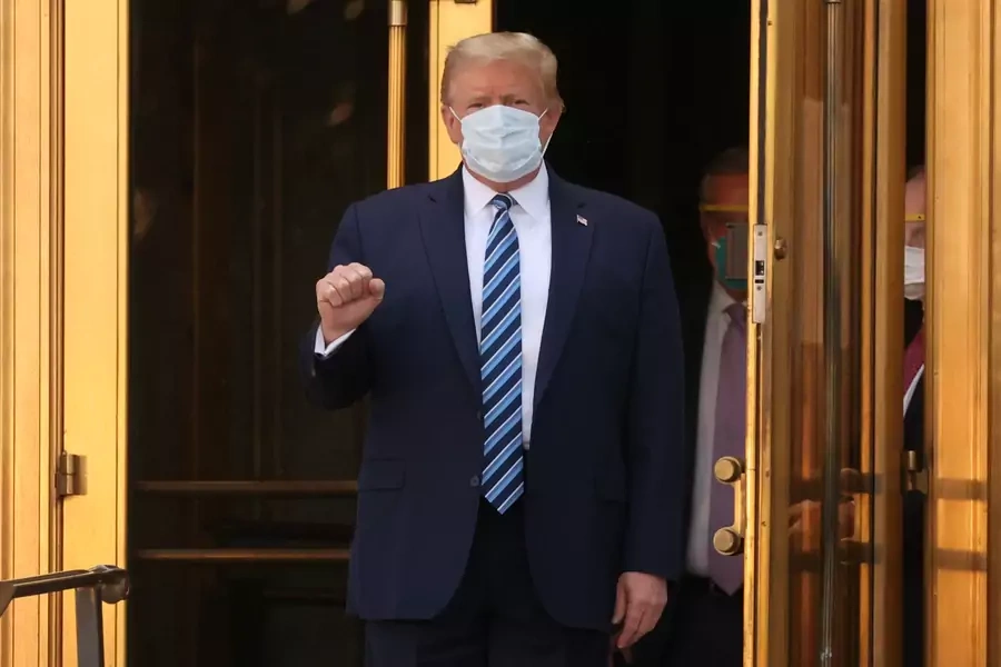 U.S. President Donald Trump makes a fist as he walks out the front doors of Walter Reed National Military Medical Center after a fourth day of treatment for the coronavirus disease (COVID-19) as he heads to the Marine One helicopter on October 5, 2020.