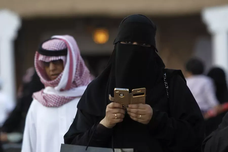 woman using an iPhone visiting the 27th Janadriya festival on the outskirts of Riyadh.