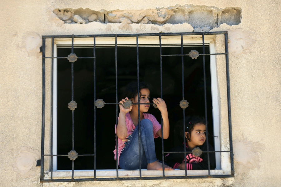 A girl watches the funeral procession of Muhammad Lateef Dar, a separatist militant, in Dogripora village