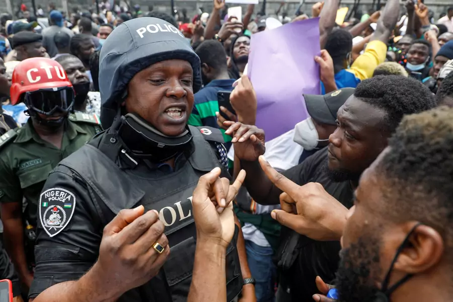 Demonstrators talk to a police officer during a protest over alleged police brutality, in Lagos, Nigeria on October 12, 2020.