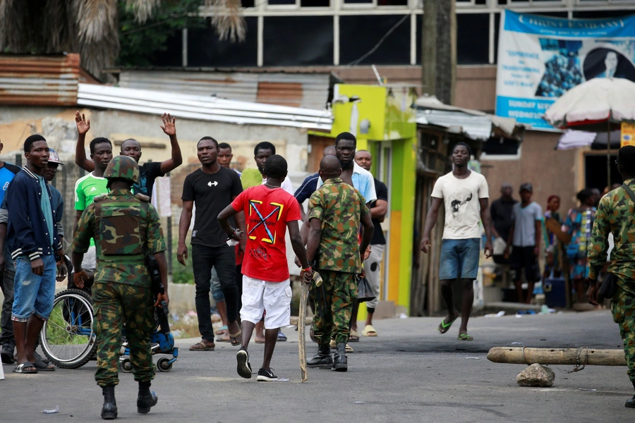 Military personnel move towards people standing along a blocked road in Ikeja, as Nigeria's Lagos state remains under curfew, Nigeria on October 23, 2020.