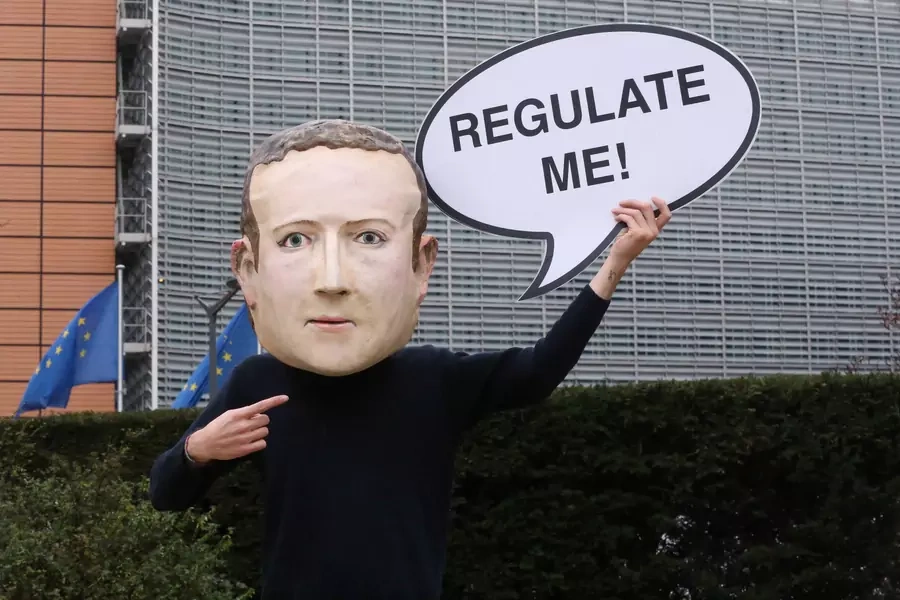 An activist of Avaaz wears a mask depicting the face of Facebook CEO Mark Zuckerberg during a protest in Brussels.