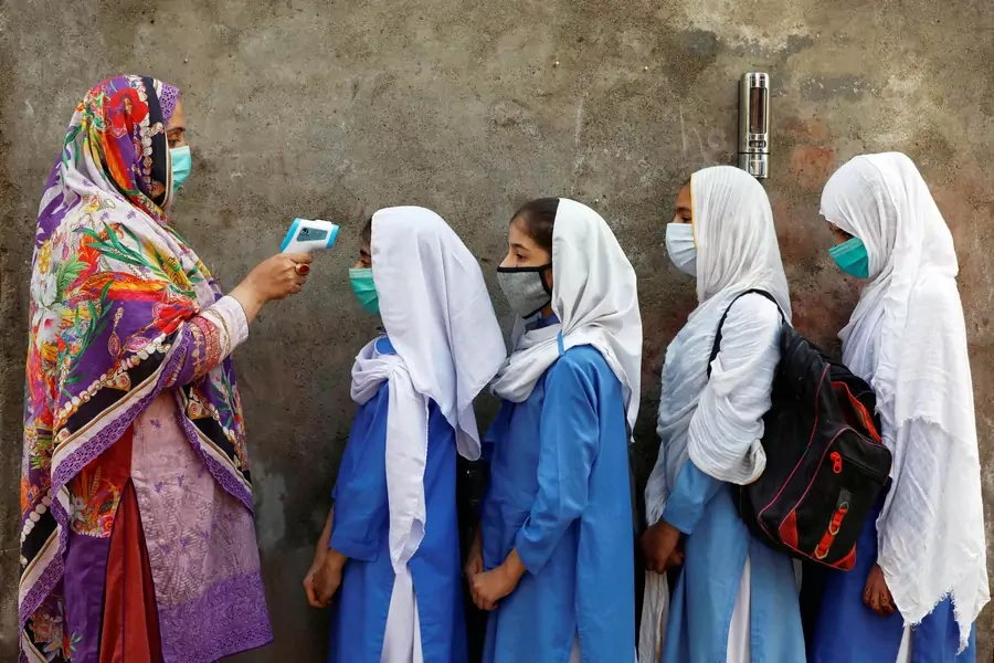Students wear face masks during temperature checks in Peshawar, Pakistan on September 23, 2020. Fayaz Aziz/Reuters