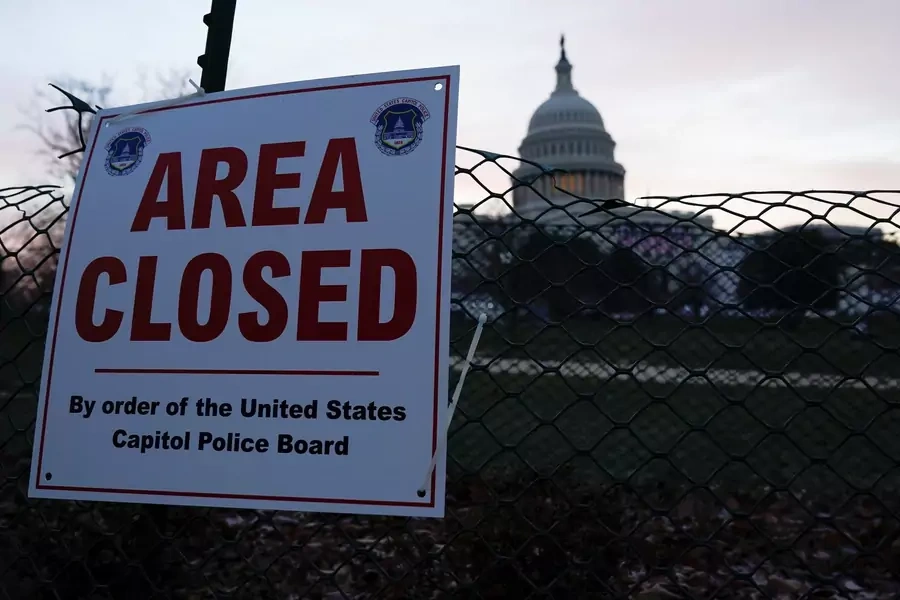 The Capitol is seen behind a fence and a sign, in Washington, D.C. on January 15, 2021.