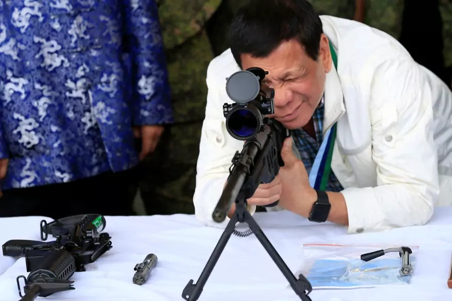Philippine President Rodrigo Duterte checks the scope of a 7.62mm sniper rifle during the turnover ceremony of China's urgent military assistance given "gratis" to the Philippines, at Clark Air Base, near Angeles City, Philippines, on June 28, 2017.