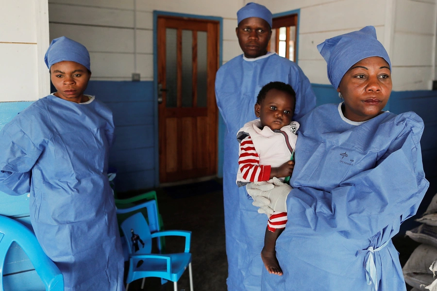 Arlette Kavugho, an Ebola survivor who works as a caregiver, carries Kambale Eloge, whose mother died of Ebola, in Katwa, near Butembo, in the Democratic Republic of Congo, on October 2, 2019.