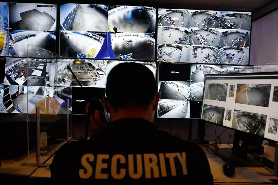 A security officer monitors surveillance cameras with geo-fencing and crowd monitoring capabilities.